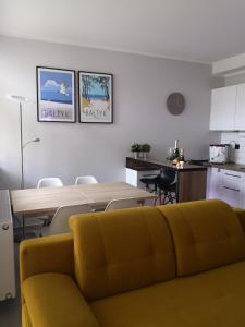 ダルウフコにあるApartament Przy Porcieのリビングルーム(黄色のソファ、テーブル付)