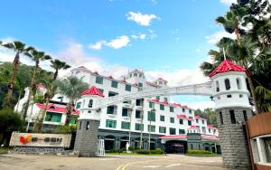 a large white building with palm trees in front of it at Uni-Resort Mawutu in Guanxi