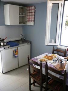 a kitchen with a table and a kitchen with a table and a tableablish at Villa Eliza in Skala