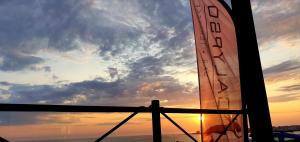 a surfboard on a boat with the sunset in the background at Hôtel La Petite Sirène Quiberon in Quiberon