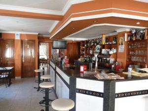 eine Bar in einem Restaurant mit Hockern in der Unterkunft Hotel Agarimo playa Areas in Areas