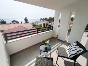 - Balcón con 2 sillas y mesa en Bloom Apartments en Vir