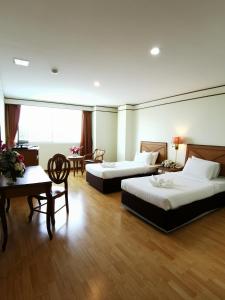 a hotel room with two beds and a desk at Morakot Twin Chumphon in Chumphon