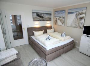 ein Schlafzimmer mit einem Sofa und Gemälden an der Wand in der Unterkunft Arielle in Westerland
