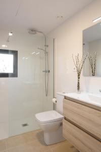 een badkamer met een douche, een toilet en een wastafel bij Apartaments La Rosella in Roses