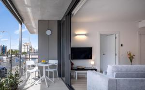 Apartaments La Rosella في روساس: غرفة معيشة مع أريكة وطاولة