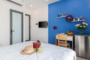 Harmony Homestay في دا نانغ: وجود قبعة على سرير في غرفة