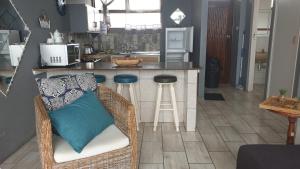 una cocina con encimera y un bar con almohadas azules en La Ballito Ocean Views, en Ballito