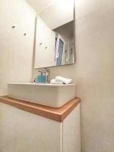 a bathroom with a white sink and a mirror at Artemis Apartment @ Plaka in Athens