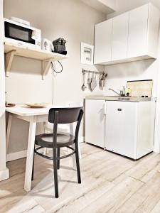 a small kitchen with a white table and a black chair at Artemis Apartment @ Plaka in Athens