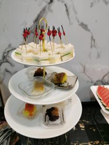 a three tiered cake on a plate with other desserts at Morakot Twin Chumphon in Chumphon
