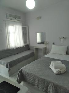 a bedroom with two beds and a window at Amorgaia 1 in Katapola