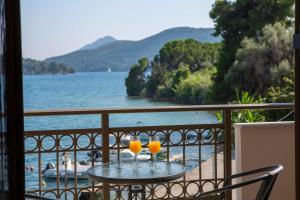 two glasses of orange juice sitting on a table on a balcony at Enalion top floor apartment with viewboat dock & close to Nidri! in Nydri