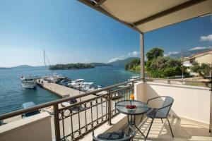 balcón con mesa y sillas y puerto deportivo en Enalion top floor apartment with viewboat dock & close to Nidri!, en Nydri