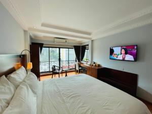 a hotel room with a bed and a flat screen tv at The Vancouver Hotel - Ninh Binh in Ninh Binh