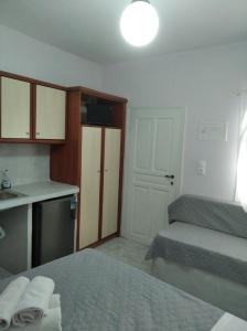a room with two beds and a kitchen with a sink at Amorgaia 1 in Katapola