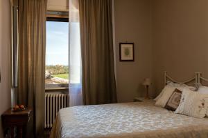 een slaapkamer met een bed en een raam met uitzicht bij Agriturismo Poggio Il Castellare in Montalcino