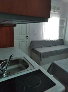 a kitchen with a sink and a kitchen with two beds at Amorgaia 1 in Katapola