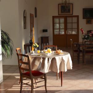 uma mesa de jantar com uma toalha de mesa branca em Le clos de Launay em Souvigné