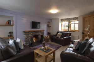 sala de estar con sofá y chimenea en Rowan Cottage, en Aviemore