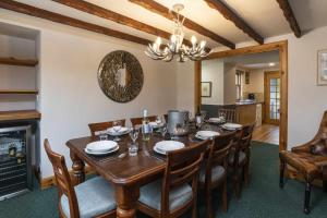 a dining room with a table and chairs and a fireplace at Rowan Cottage in Aviemore