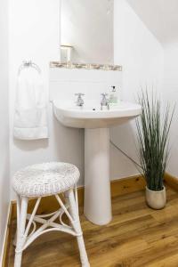 La salle de bains est pourvue d'un lavabo, d'un tabouret et d'un miroir. dans l'établissement Rowan Cottage, à Aviemore