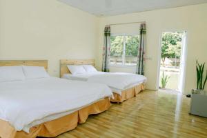 twee bedden in een witte kamer met twee ramen bij Trang An Pristine View homestay in Ninh Binh