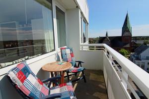a balcony with two chairs and a table and a window at Kiekerwai in Westerland