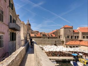 a person walking on a bridge in a city at Apartments Franka Old Town in Dubrovnik