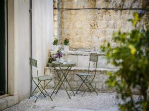 a table and chairs sitting on the side of a building at Apartments Franka Old Town in Dubrovnik