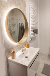 a bathroom with a white sink and a mirror at Apartamenty na Wzgórzu in Bochnia +32 photos