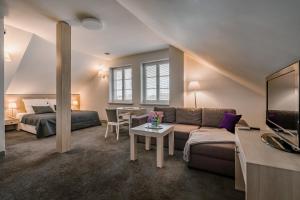 a living room with a couch and a bed and a table at Hotel&SPA Dwór Droblin in Leśna Podlaska