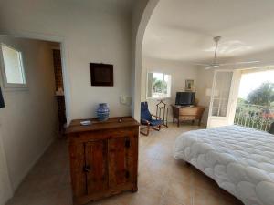 a bedroom with a bed and a room with a television at Villa Le Sud in Les Issambres