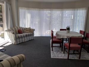 sala de estar con mesa y sofá en Quiet location with view and public transport en Wellington