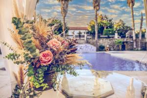 un jarrón con flores en una mesa junto a una piscina en Quinta de Resela, en Vila Verde