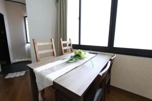 a wooden table with flowers on top of it at Liz4 Guest House Liz Nakazakicho in Osaka