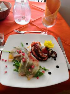 um prato branco com comida numa mesa em Hotel Crown em Rimini