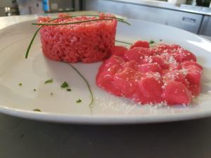 een witte plaat met rood eten op een tafel bij Hotel Crown in Rimini
