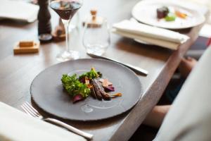 a wooden table with a plate of food on it at Trasti & Trine Boutique Hotel in Alta
