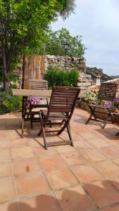 twee banken en een picknicktafel op een patio bij Casa Cabra in Montejaque