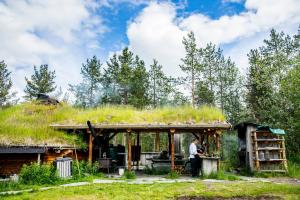 a man standing in front of a house with a grass roof at Trasti & Trine Boutique Hotel in Alta