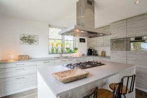 een keuken met witte werkbladen en een fornuis met oven bij Hoogelandt 106F in De Koog
