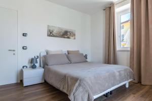 a white bedroom with a bed and a window at Villa Vacanze Pink Lady in Tuenno
