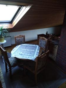 ein Esszimmer mit einem Tisch, Stühlen und einem Fenster in der Unterkunft Ferienhaus Ullrich in Augustusburg