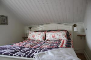 łóżko z kołdrą i poduszkami w pokoju w obiekcie Kolmårdstorpet Blomsätter w mieście Kolmården