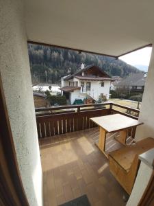 a balcony with a table and a view of a house at Appartamento Norma in Val di Vizze