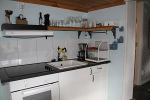 eine Küche mit weißen Schränken und einer Spüle in der Unterkunft Kolmårdstorpet Blomsätter in Kolmården