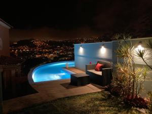 a backyard with a swimming pool at night at Casa da Quinta in Funchal