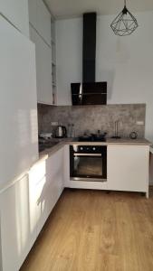 una cucina con armadi bianchi e piano cottura di SKY Apartment a Vlorë