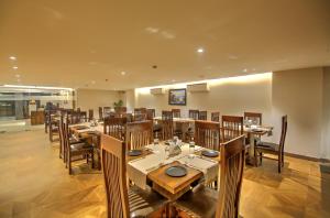 uma sala de jantar com mesas e cadeiras de madeira em Hotel 91 Huda City Centre em Gurgaon